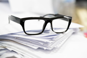 Paper heap from hard work is under black glass