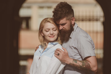 She is the center of his universe. Couple in love. Bearded man hug sexy girl. Sensual woman and man enjoy romantic date. Loving couple of woman and hipster dating outdoor. Feeling love and romance