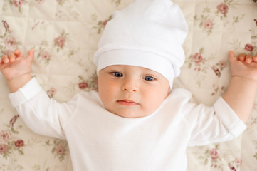 Portrait of a crawling baby on the bed in her room