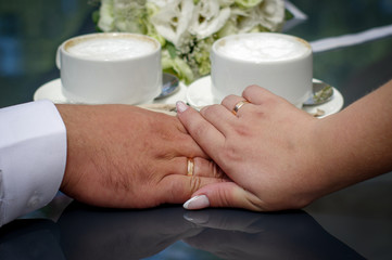 Hands of the bride and groom with gold wedding rings. Wedding concept.