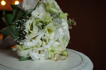 Horizontal shot of wedding rings with a bouquet of the bride. The concept of a wedding day