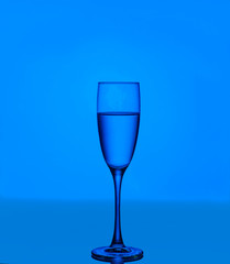 Glass on a blue background. Minimal night party life concept
