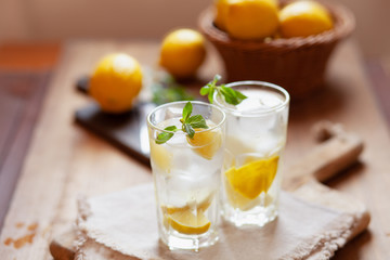 Refreshing summer drink with lemon, mint and ice copy space - obrazy, fototapety, plakaty