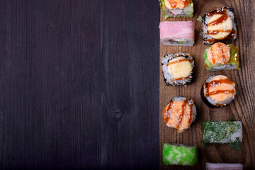 Assortment of baked and fresh sushi rolls on a wooden board. Japanese cuisine