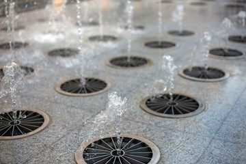 Splashes of water from a fountain in the summer in the city