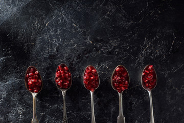 Flat lay with pomegranate seeds and silver cutlery