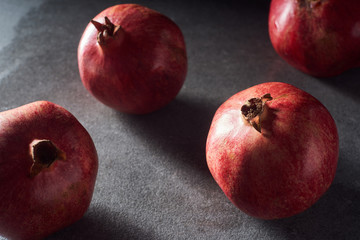 Fototapeta na wymiar Studio shot of fresh pomegranates on black surface