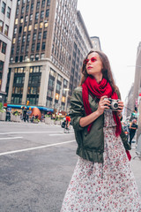 Naklejka premium Attractive girl with a retro camera in the city