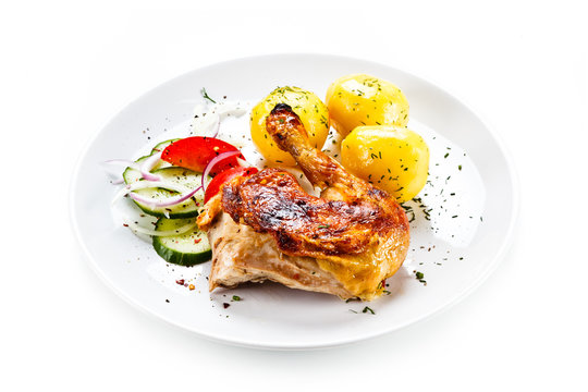 Grilled chicken leg with vegetables on white background