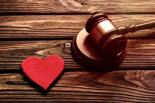 red heart, judge hammer on wooden table background.  family law.