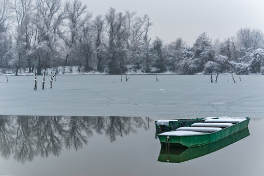 Beautiful frozen river. A boats covered with snow.