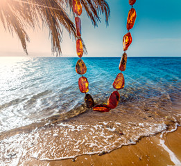 Beads necklace of beautiful amber on the waves of Red Sea background