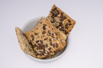  cookies with  poppy seeds and sesame seeds in a porcelain bowl