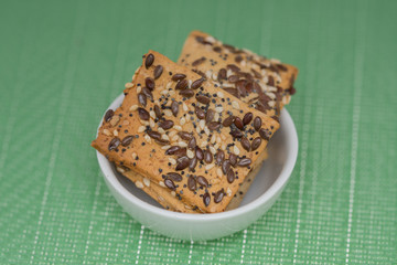  cookies with  poppy seeds and sesame seeds in a porcelain bowl