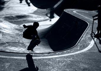 Skater als silhouette im Gegenlicht, im Hintergrund Skatepark