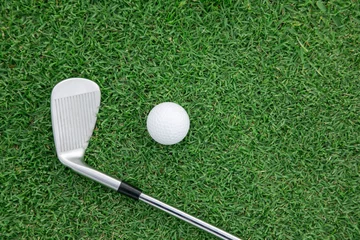 Fotobehang Golf Top view of iron golf club and golf ball on the green grass  © charnsitr