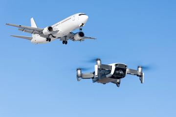 Drone flying near commercial airplane in the airport.