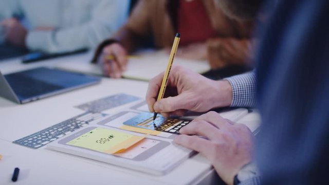 UX Designer, mobile app developer outlines an app on paper with template -UX Designer , Mobile App-Entwickler skizziert eine App auf Papier mit Schablone  4k PRORES Footage