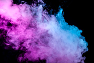 A thick column of smoke from a pair of vape on a dark background, illuminated by neon blue and purple.
