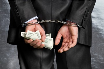 Cropped image of male hands in handcuffs behind his back