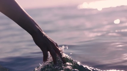 close up woman hand touching water waves splashing tourist enjoying boat ride