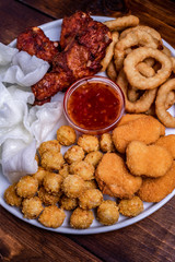 beer plate: chicken nuggets, onion rings in tempura, chicken popcorn, rice chips, fried chicken pieces and ketchup