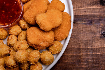 part of the beer plate with chicken nuggets, onion rings in tempura, chicken popcorn, rice chips, fried chicken pieces and middle pepper sauce