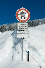 Verschiedene Verkehrsschilder an einer verschneiten Straße