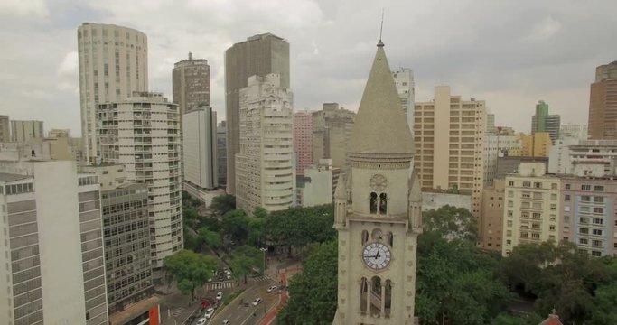 Wider aerial circling clocktower in downtown urban Sao Paulo cityscape