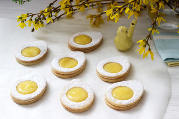 Homemade Easter lemon cookies and forsythia blooming twigs on a light background.