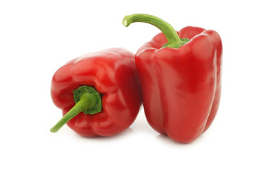 two red bell peppers (capsicum) on a white background