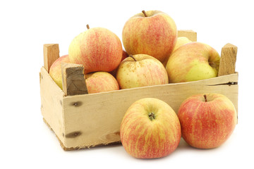 fresh cooking apples in a wooden crate on a white background