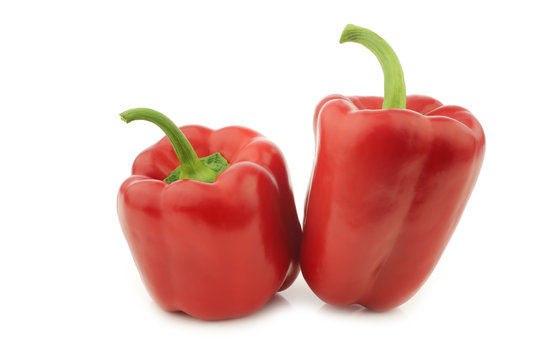 two red bell peppers (capsicum) on a white background