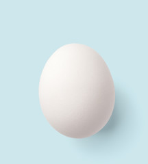 white egg isolated on blue with clipping path