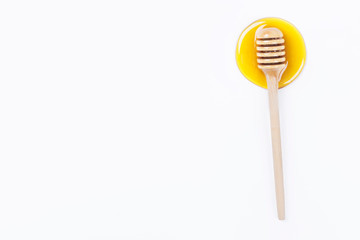 Honey dipper in honey and a jar of honey isolated on light grey background