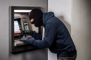 Hacker stealing password and identity on atm machine. Computer crime concept.