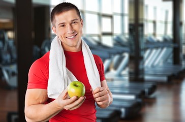 Handsome athletic man with towel on neck in gym