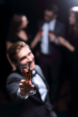 stylish young man standing with a glass of champagne.