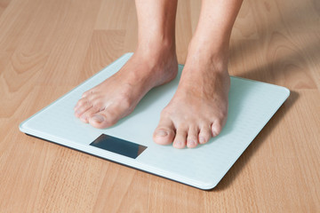 Legs on the scales. Checking the weight. Losing weight.
