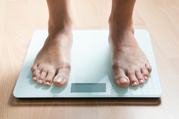 Legs on the scales. Checking the weight. Losing weight.