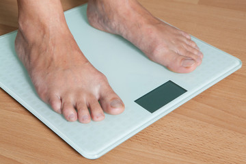 Legs on the scales. Checking the weight. Losing weight.