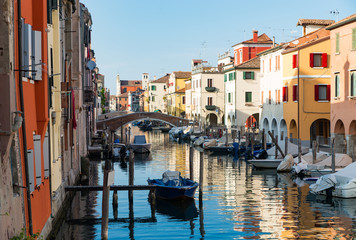Chioggia, Venice, Italy: city landscape with canal, ancient bridge, boats