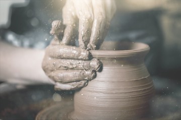 Hands of potter making clay pot