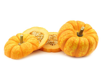 Small yellow and orange pumpkin and a cut one on a white background