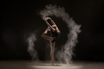 Brunette dancing gracefully in white dust cloud