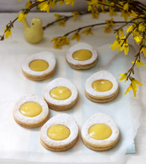 Homemade Easter lemon cookies and forsythia blooming twigs on a light background.