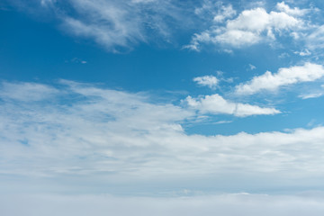 Blue sky background, viewed from an airplane window.