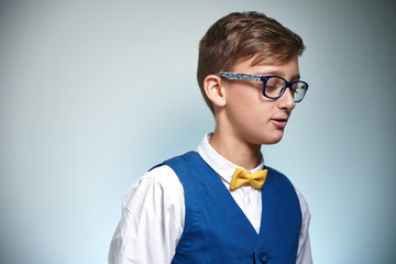 Teen boy with glasses. Wearing a shirt with a bow tie.