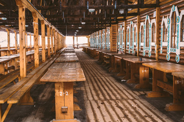 An empty indoor flea market with wooden numbered tables and benches in the Izmailovo Kremlin