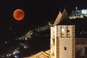 The red blood moon over the Caceres old town